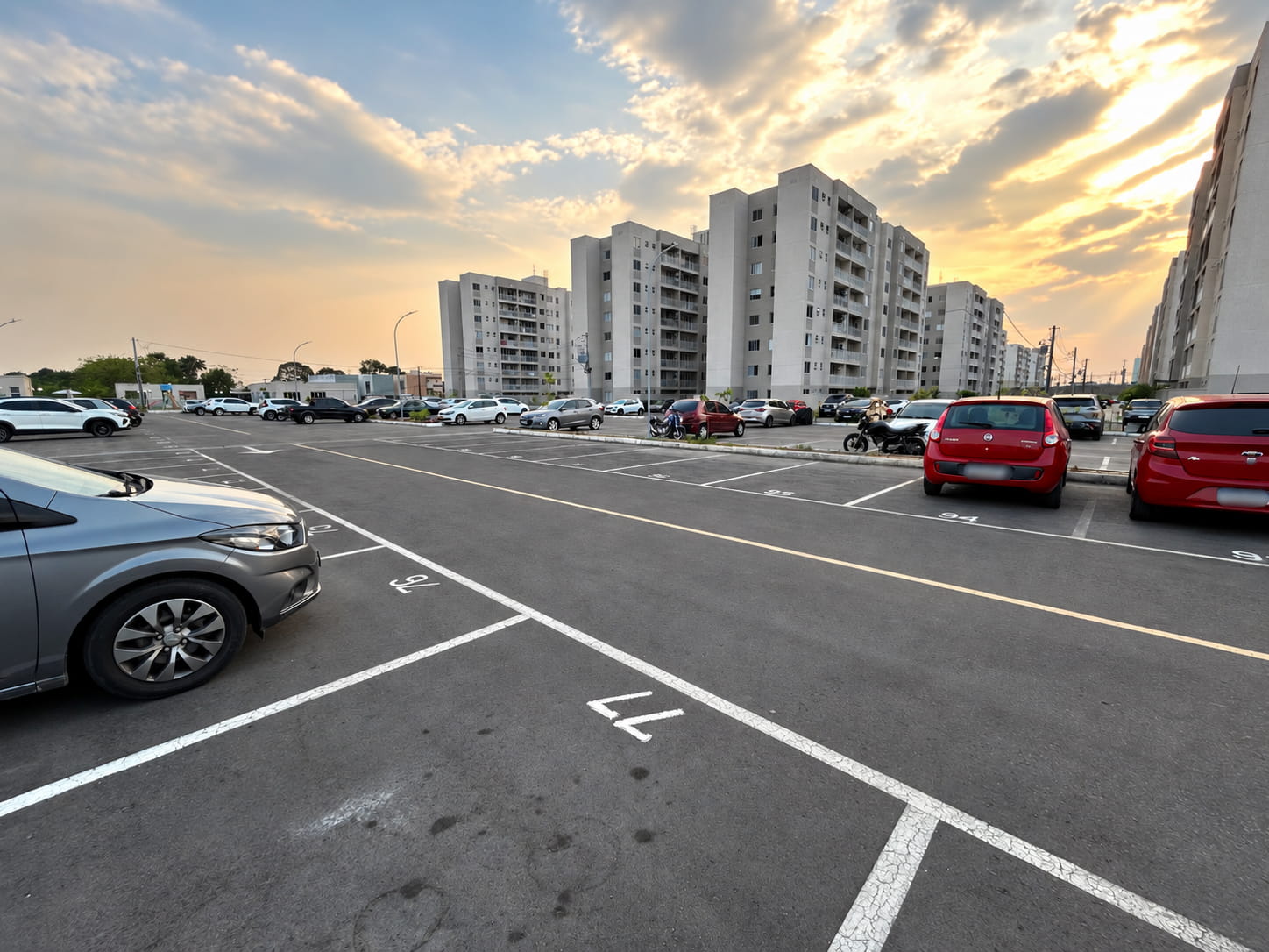 Estacionamento e torres de um condomínio residencial em Manaus, sem árvores