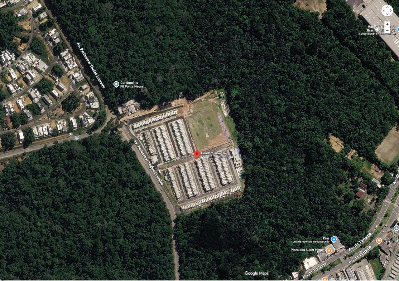 Visão aérea de um condomínio recém-construído cercado de floresta, próximo à Estrada do Turismo